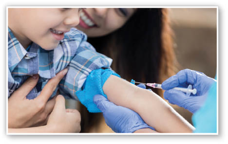 Unrecognizable medical professional takes a blood sample from elementary age Hispanic boy at free outdoor clinic  The boy s mother is comforting him 