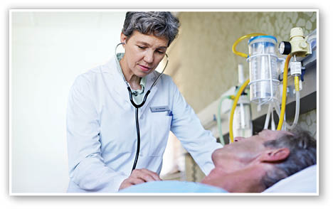 Shot of a doctor doing tests on a mature man lying in a hospital bed